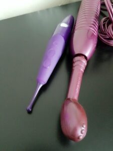 Purple Eroscillator and Zumio oscillating vibrators "stored" on nightstand