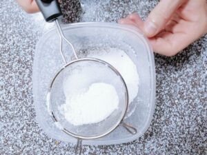 My boyfriend sifting powdered sugar