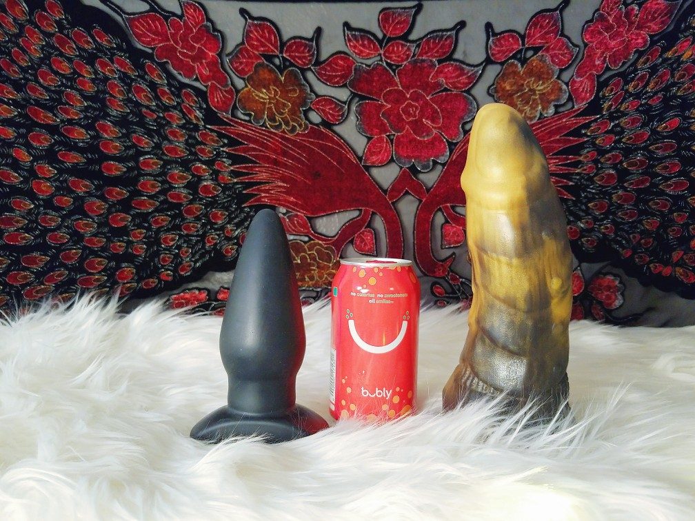 Tantus Ringo next to soda can and large Frisky Beast / Twin Tail Creations Cybersaur dildo