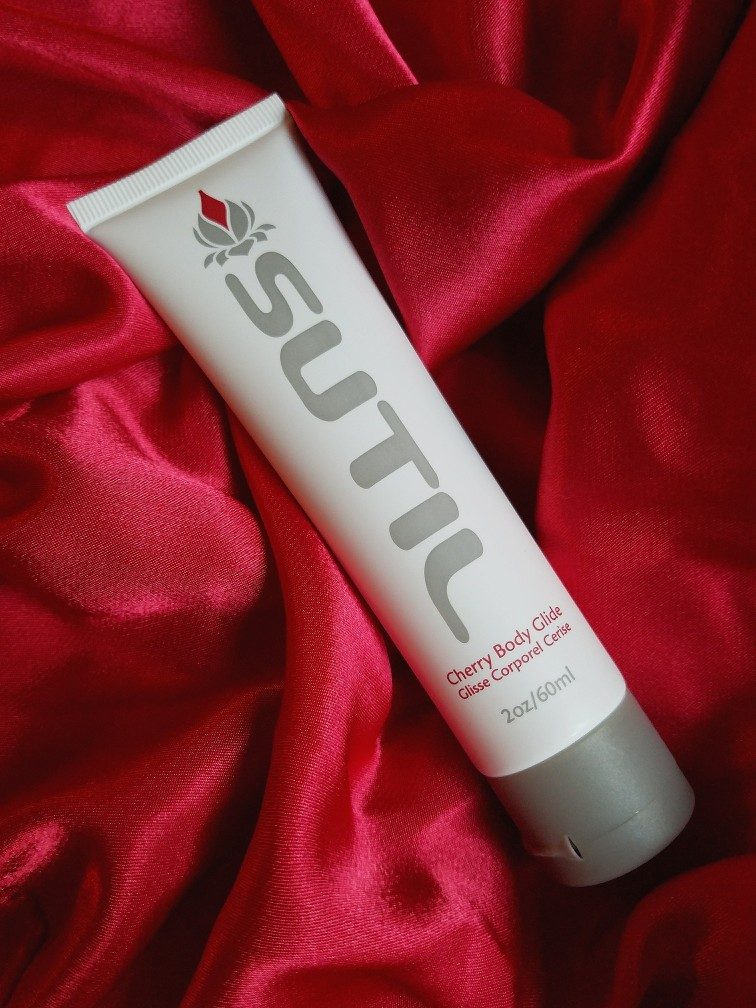 Hathor / SUTIL Body Glide cherry flavour lube tube on red satin