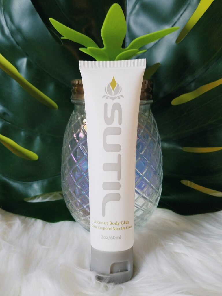 Hathor / SUTIL Body Glide coconut flavour lube tube in front of a pineapple-shaped jar