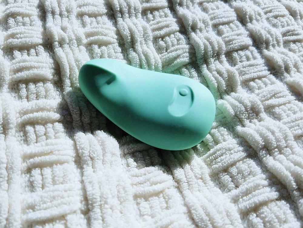 Pom vibrator by Dame Products jade green side view with defined beak in shadow