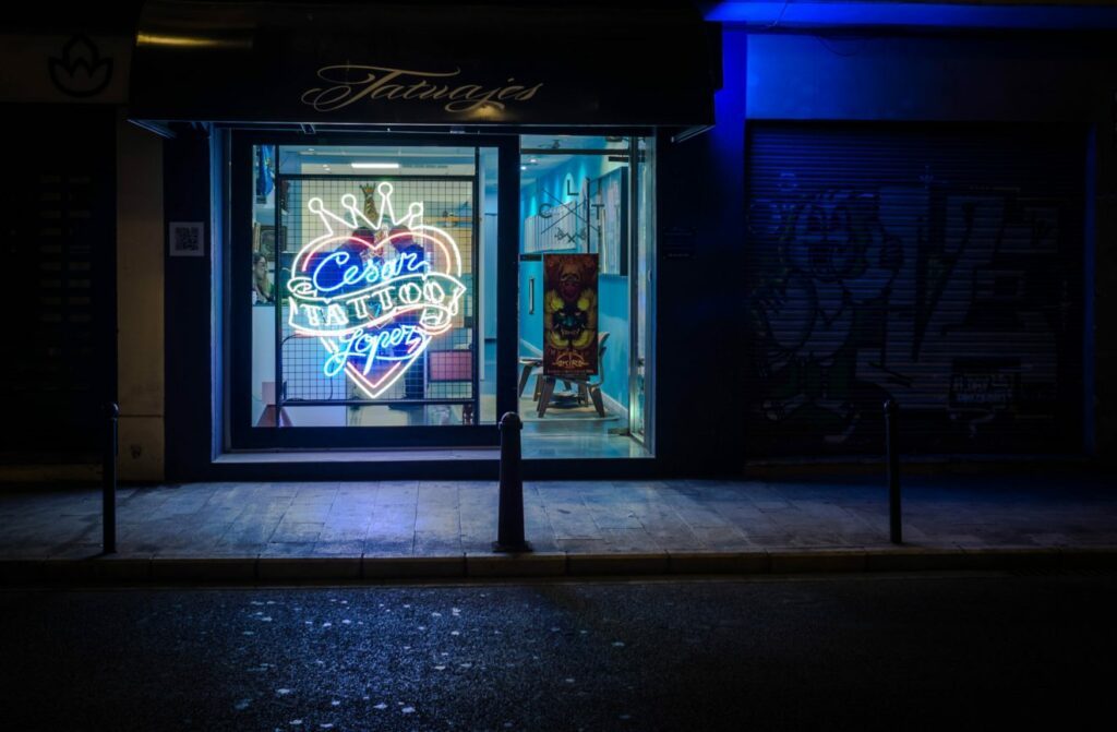 3 Reasons I Want More Body Mods 1 Tattoo parlor with neon sign