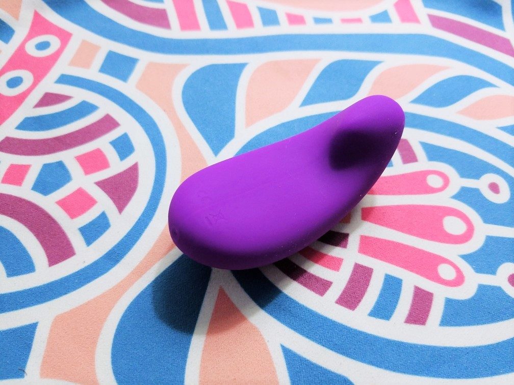 [Image: 3/4 view of my purple Vibease, showing its curves designed to nestle along the vulva]