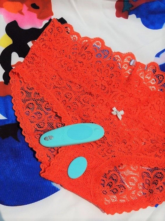 [Image: teal blue We-Vibe Moxie with magnet detached on orange lace panties]