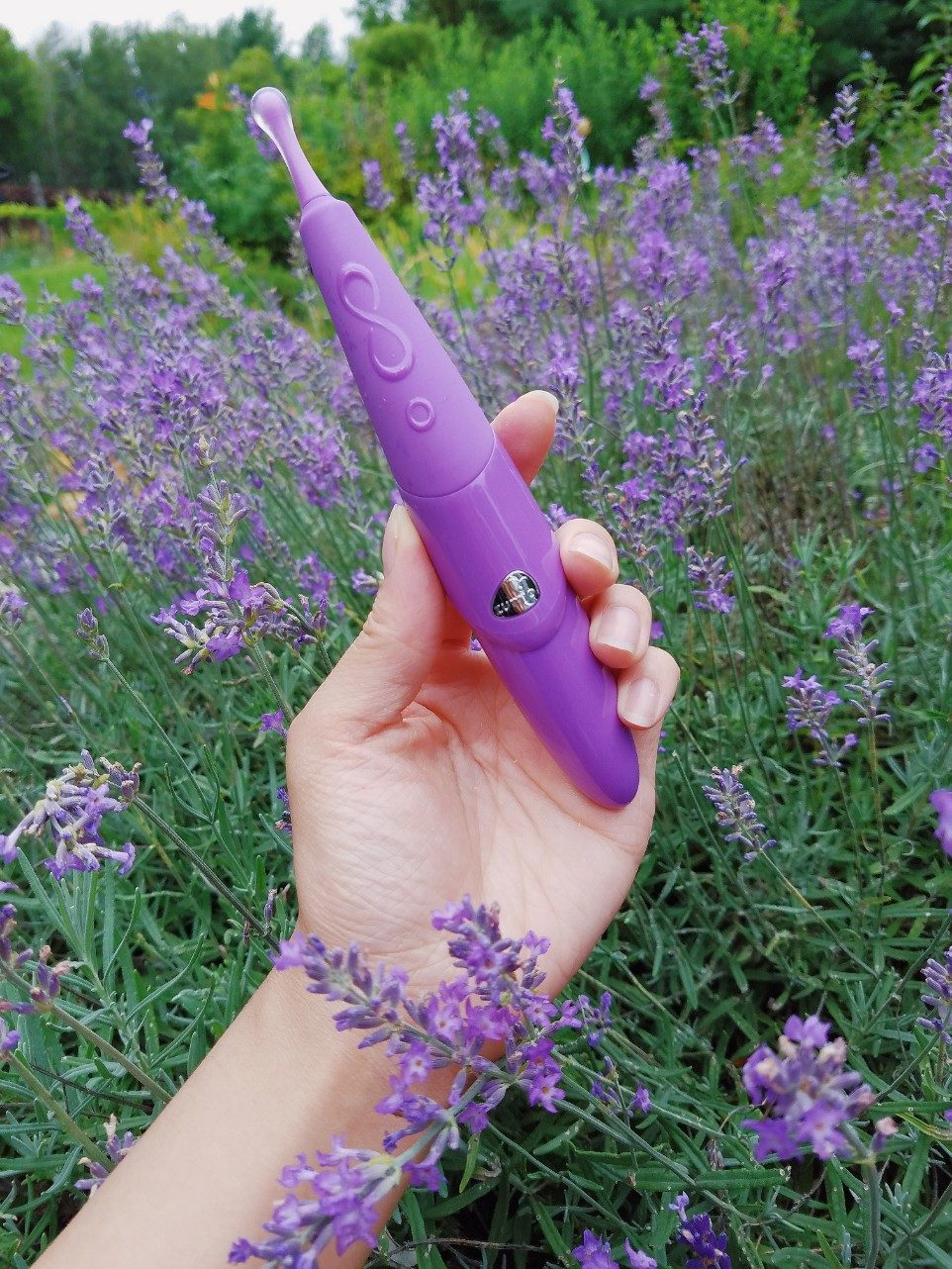 [Image: holding the Zumio S Caress in my hand. It is a light lavender purple with a clear silicone coating on the tip to make it more gentle than the original Zumio.]