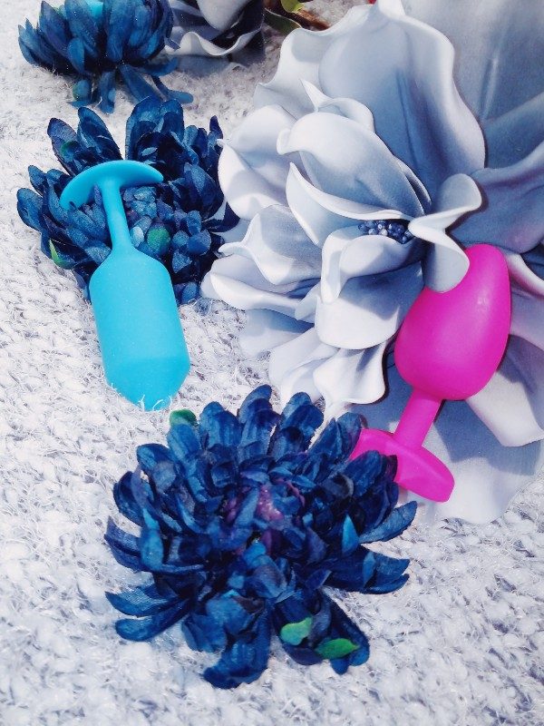 [Image: b-Vibe Snug Plug 3 medium in teal and FT London Bioskin Gplug among blue and gray flowers]