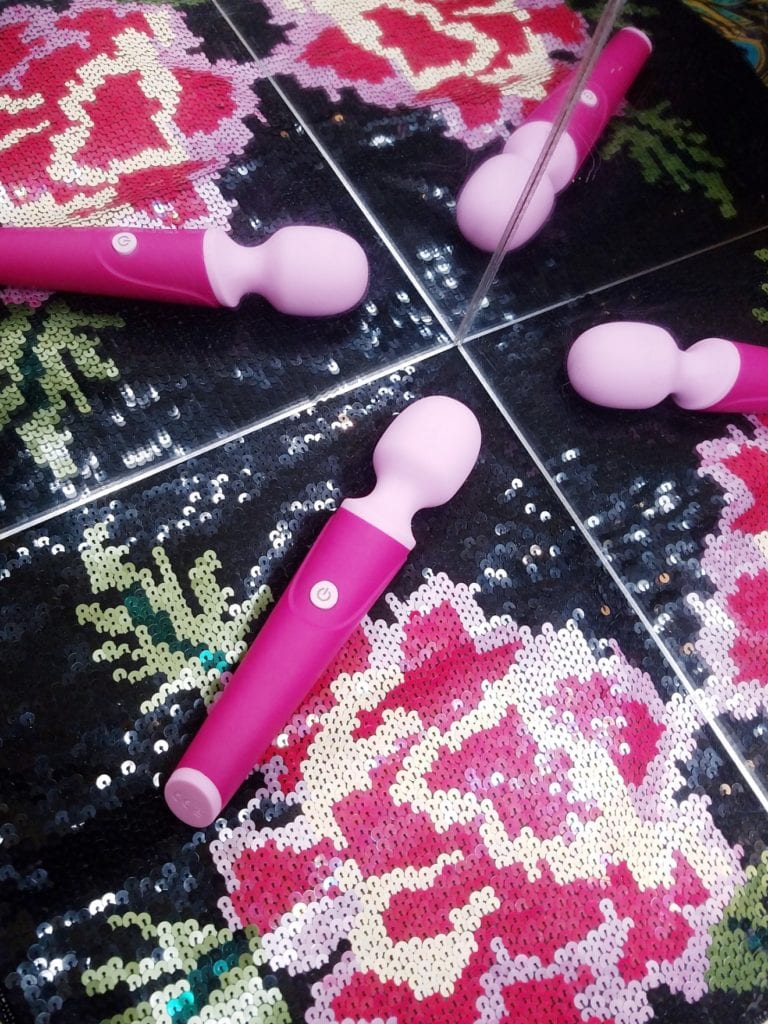 [Image: Blush Noveltes W4 Mini-Wand in lily pink in front of mirror]