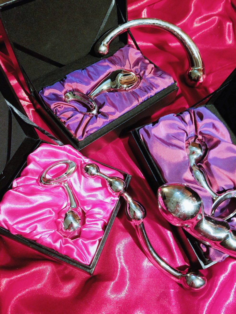 [Image: njoy stainless steel sex toy boxes with red and pink satin]