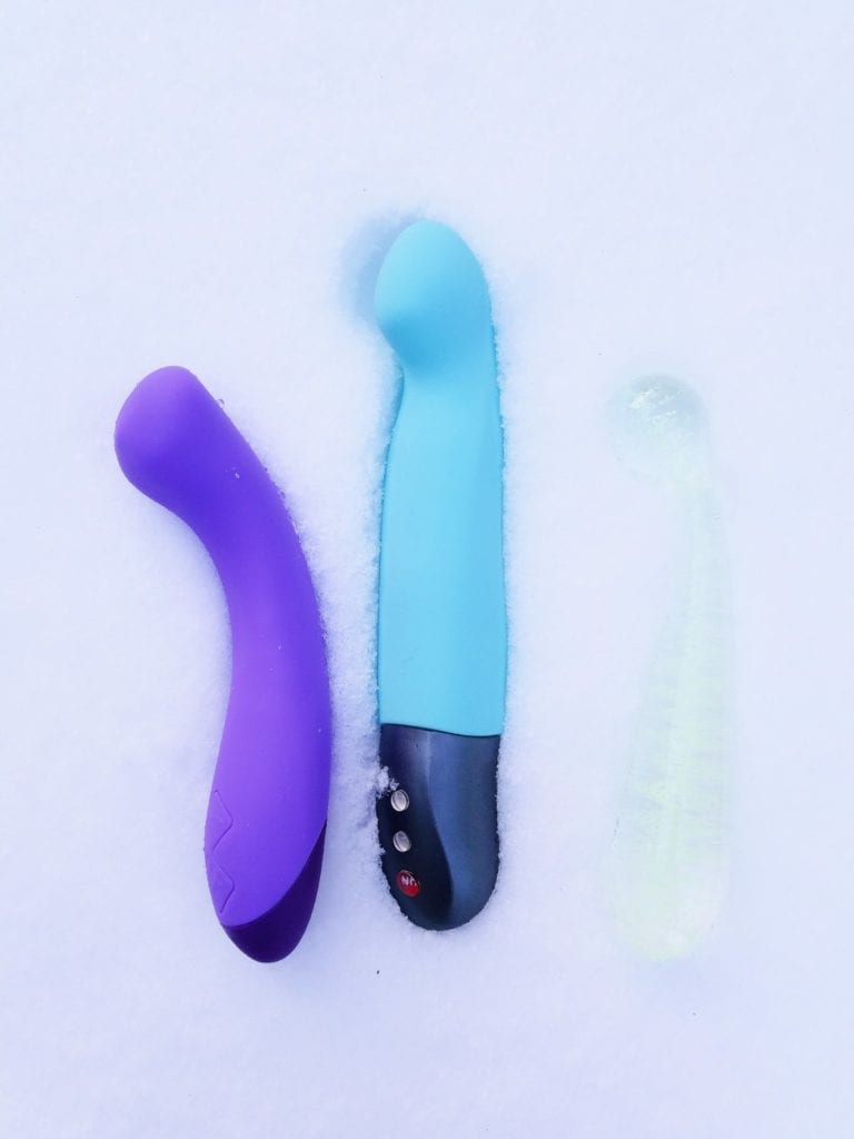 [Image: purple Blush Novelties Wellness G Ball G-spot vibrator next to pool blue Fun Factory Stronic G Pulsator and clear NS Novelties Glass G Wand]