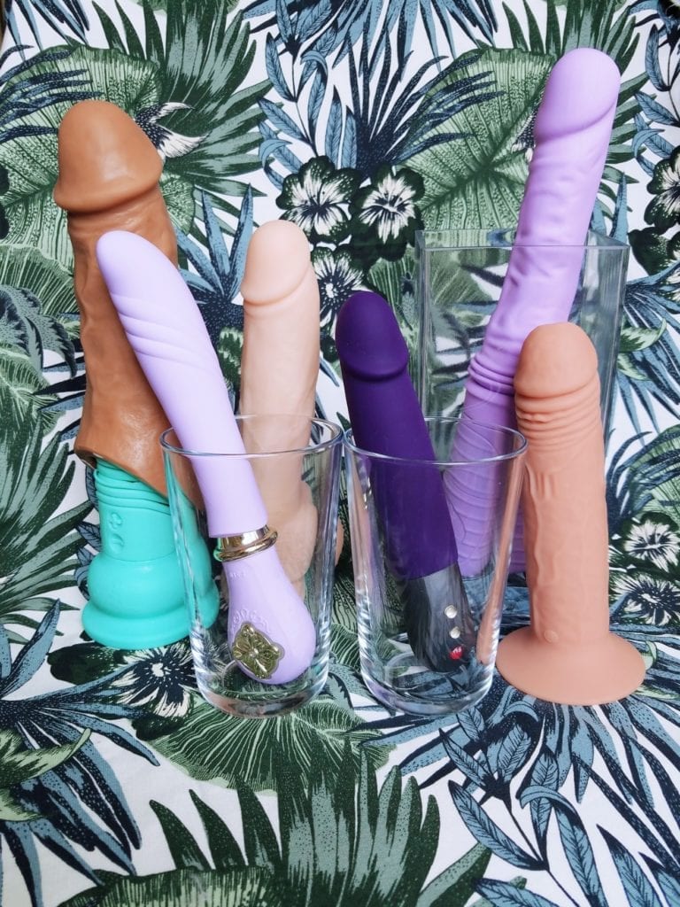 [Image: Self-thrusting dildos in flesh, purple, and teal. Left to right: Velvet Thruster Teddy with VixSkin Colossus extension sheath, Zalo Sweet Magic Desire, BMS Factory Naked Addiction 9" self-thrusting dong, Fun Factory Stronic Real Pulsator II, original Velvet Thruster Jackie, XR Thump It 7.25]