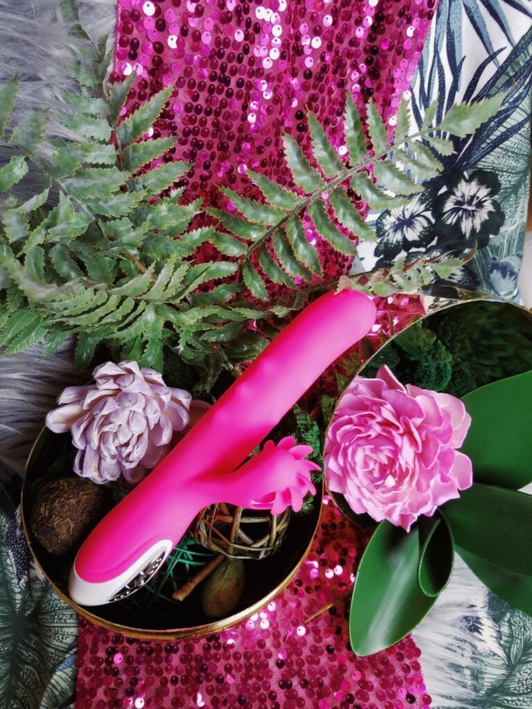 [Image: pink Evolved Novelties Love Spun rabbit vibrator side view among fake plants]