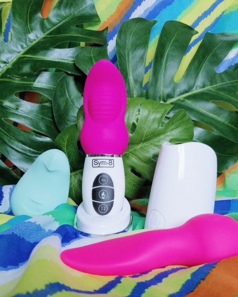 [Image: jade green Dame Pom flexible vibrator next to Sym-B Kiki rechargeable clitoral vibrator and Mini Marvels by Cal Exotics]