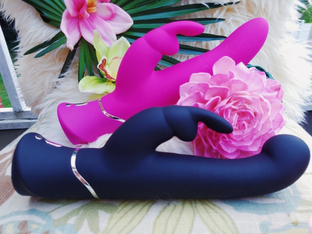Close-up of the Lovehoney Happy Rabbit G-Spot Stroker rabbit vibrator with the Curve thrusting rabbit in the background
