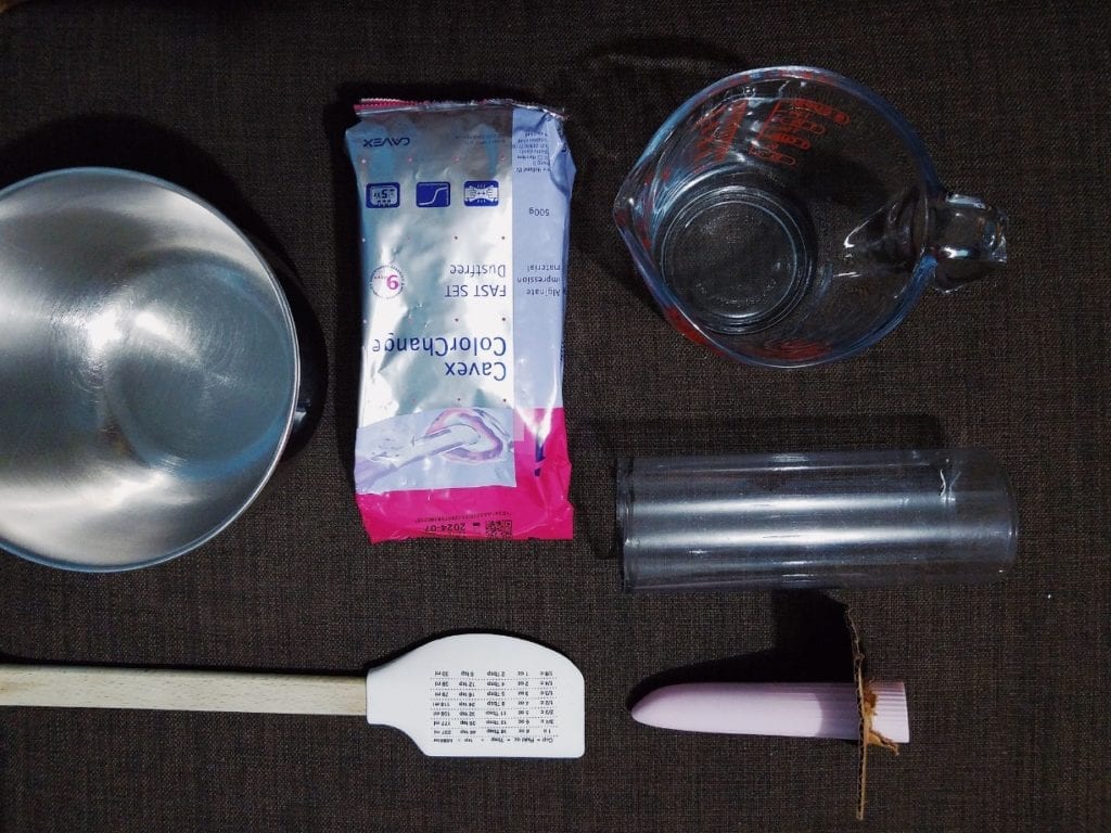 Mixing bowl, dental alginate, measuring cup, trimmed Clone-A-Willy tube, mixing spatula, bullet