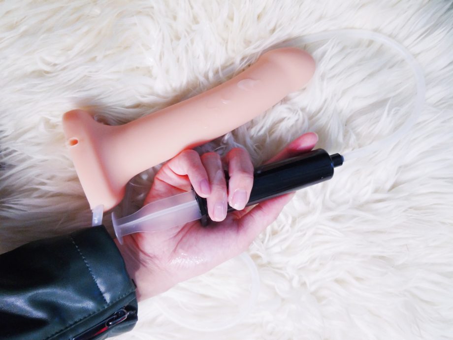 Strap On Me silicone ejaculating dildo syringe in hand