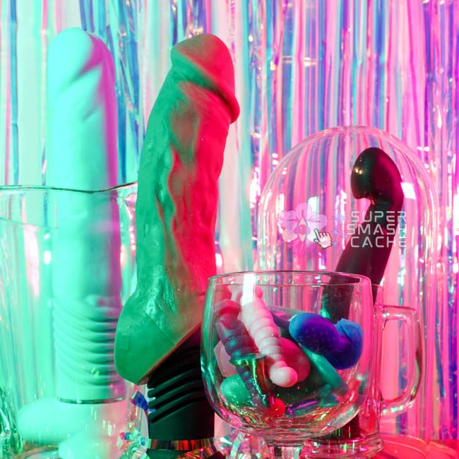 Velvet Thruster, Vixen Creations, and Fun Factory sex toys in front of holographic streamer background