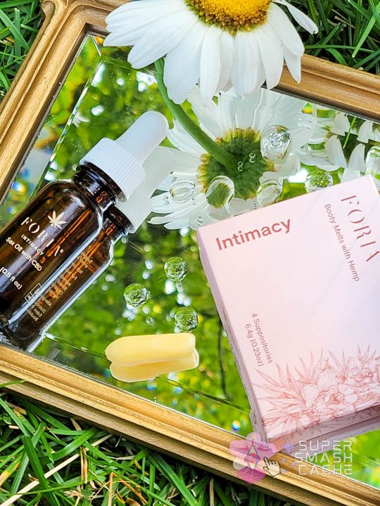 Foria CBD Booty Melts suppository and Intimacy Sex Oil on mirror
