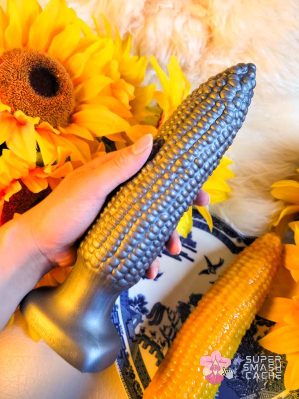 A hand holding Squarepegtoys' Cob A Squat corn dildo