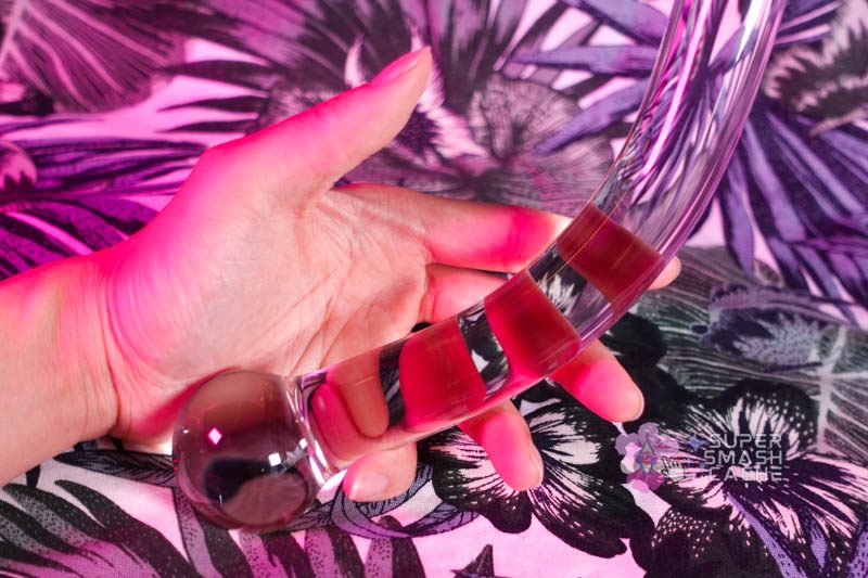 Holding the ball end of the Luscious Playthings curved borosilicate glass dildo