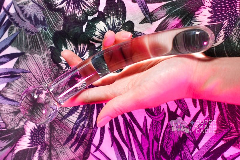 Hand holding a gently curved glass dildo from Luscious Playthings