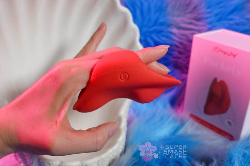 Tracy's Dog Pockety finger vibrator in red shown from side angle, displaying flexible silicone finger loop and compact size