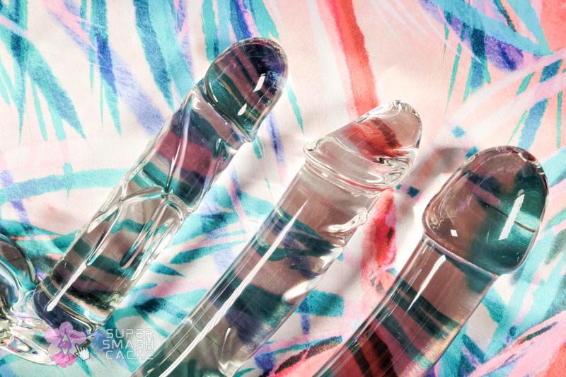 Three handcrafted glass pleasure wands displayed side by side, showcasing varied girths and realistic textures in clear borosilicate material