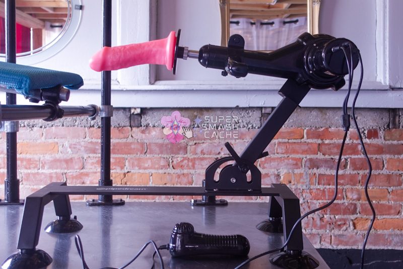 Body Dock Pro black sex machine with metal construction, dual articulating joints, and universal suction cup adapter for various dildo attachments