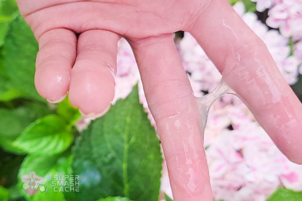 Fingers pulling apart realistic fake cum showing stretchy viscous texture of homemade artificial semen recipe
