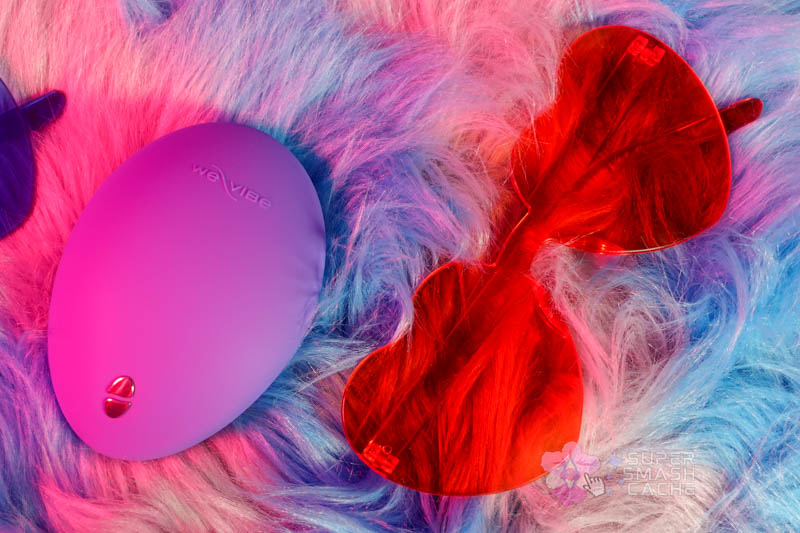 We-Vibe Temp vibrator flat lay top view next to heart-shaped party sunglasses